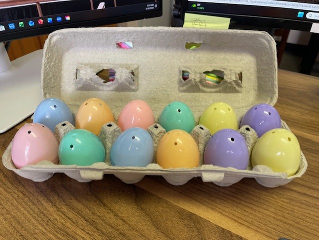 A dozen colorful plastic eggs arranged in a carton